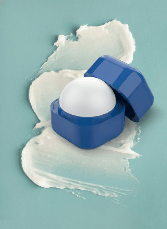 Open blue lip balm container showing its rounded white balm.